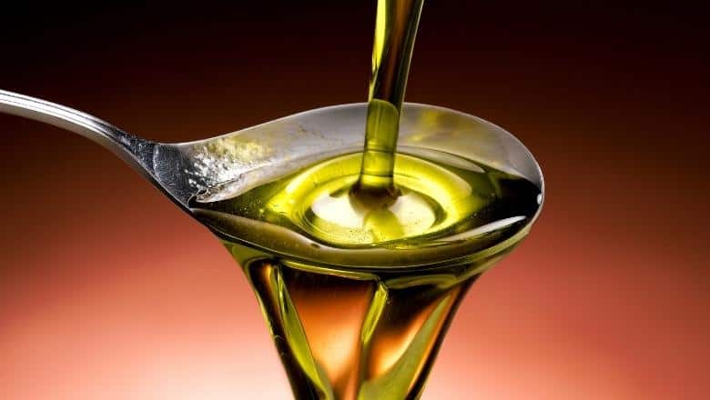 pouring olive oil to spoon