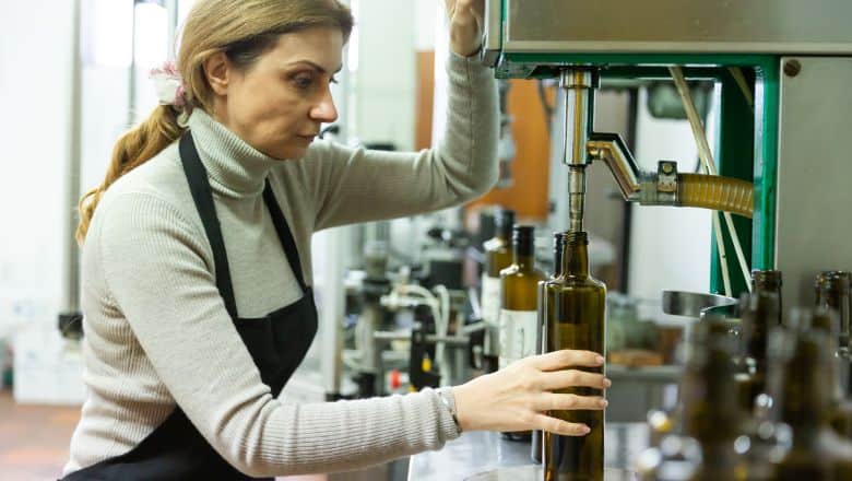 woman filling bottles with olive oil